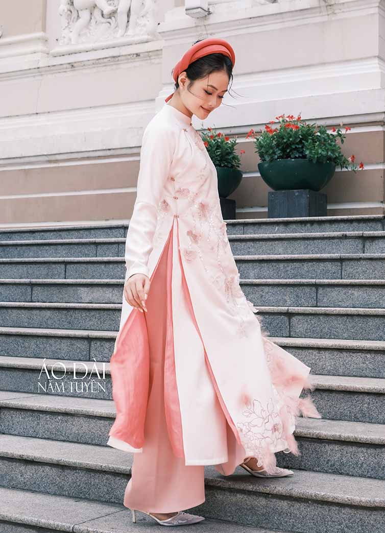 Áo dài ngũ thân nữ trắng kem phối lót hồng – Hoa kết và lông vũ tạo điểm nhấn 